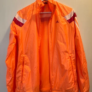 Träningsjacka från Adidas  - Orange träningsjacka från Adidas. Fint skick. Strl. S. 