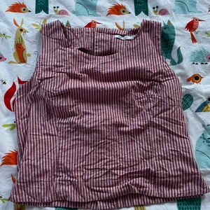 Randig väst - Säljer en randig västaktig tröja i hårt tyg i röd vit randigt tyg med söta knappar längs ryggen