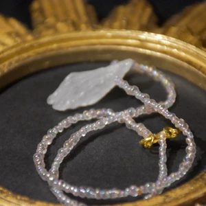 Halsband bergskristall - Halsband med rå bergskristall och rosa skimrande pärlor. Låset är guldigt och halsbandet är rätt kort, gjort för att ligga i halsgropen.