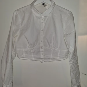 H&M divided, cropped shirt  - Size 44, small in size. Used, but no visable damage. Goes well together with a knitted vest or just together with jeans/trousers