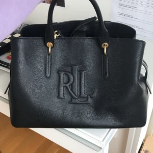 Lauren Ralph Lauren väska  - Nu säljer jag min väska från Lauren Ralph Lauren. Väskan är andvänd 2 ggr så den är i mycket god skick och sparsamt andvänt. Väskan är stor och rymmer mycket då det passar bra till exempel skolan då man kan få plats med en dator och böcker. Vid frågor eller funderingar så är det bara att höra av sig. Jag skickar gärna flera bilder om så önskas! Köparen står för frakt! ❤️