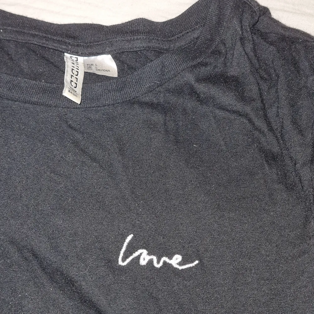 Svart tshirt i strl L. Men texten 'Love' på väntra bröstet . T-shirts.