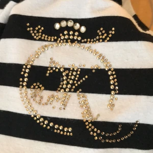 Tshirt - Säljer en jättecool topp med döskalletryck i nätt på ryggen och på knapparna! Säljer för att det inte riktigt är min stil, högst bud vinner! rosetten på ryggen i mitten sitter lite löst men går enkelt att sy fast den lite mer om man vill!              Märkt som M/L men Sitter som en S men passar en XS och en M 