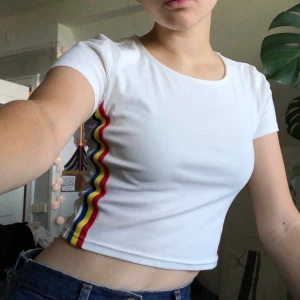Baby crop top med rand - Urgullig o snygg croptop som jag köpte typ tre år sen men använt max 1 gång, för det inte riktigt är min stil/form. Snygg halvdjup urringning och en gul/blå/röd rand på sidan. Väldiga 80-90tals vibes men nyproduktion. 