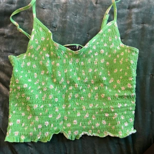 Grönt blommigt linne - Super gulligt grönt linne med blommor. Köpt på asos. Använd ett fåtal gånger, precis som ny. Strlk 38 men passar mindre