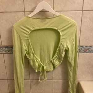 Croptop från nakd  - Otroligt snygg croptop i cool grön färg, öppen i ryggen med knytning. Använd 1 gång. Frakt ingår ej💚