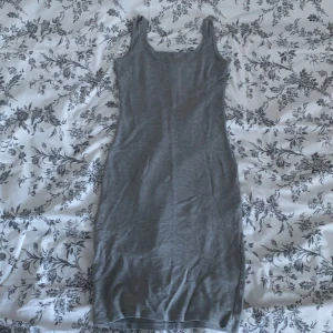 Tight grå klänning  - En tight grå klänning köpt på pullnbear. Den var för lång i armarna så jag sydde dem lite kortare, annars helt fel fri!