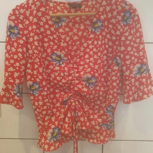 Somrig top från Topshop med dragsko i midjan  - Top med dragsko i midjan och lite volang i armen. Bra skick, passar 36-38 beroende på vilken passform man vill åt. 