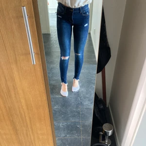 Slitna skinny jeans - Ett par lågmidjade skinny jeans från Bershka med slitningar på knäna. Säljer pga att de börjar blir lite små för mig. Sparsamt använda! Frakten ingår ej i priset💚