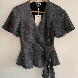 Oanvänd topp - Svart/glittrig topp som passar till fest eller även till vardags för lite extra glam. Helt oanvänd i perfekt skick, från Bubbleroom