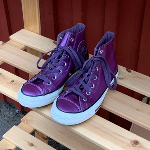 Converse i unik lila färg  - Supercoola lila Chuck Taylors med metallisk yta! Lite tjockare och mer läderlika i tyget. Bra skick. Den medföljande boxen anger originalpriset som $479. Blir kanske ännu snyggare med vita eller mönstrade snören? Storlek 5 dvs 37,5