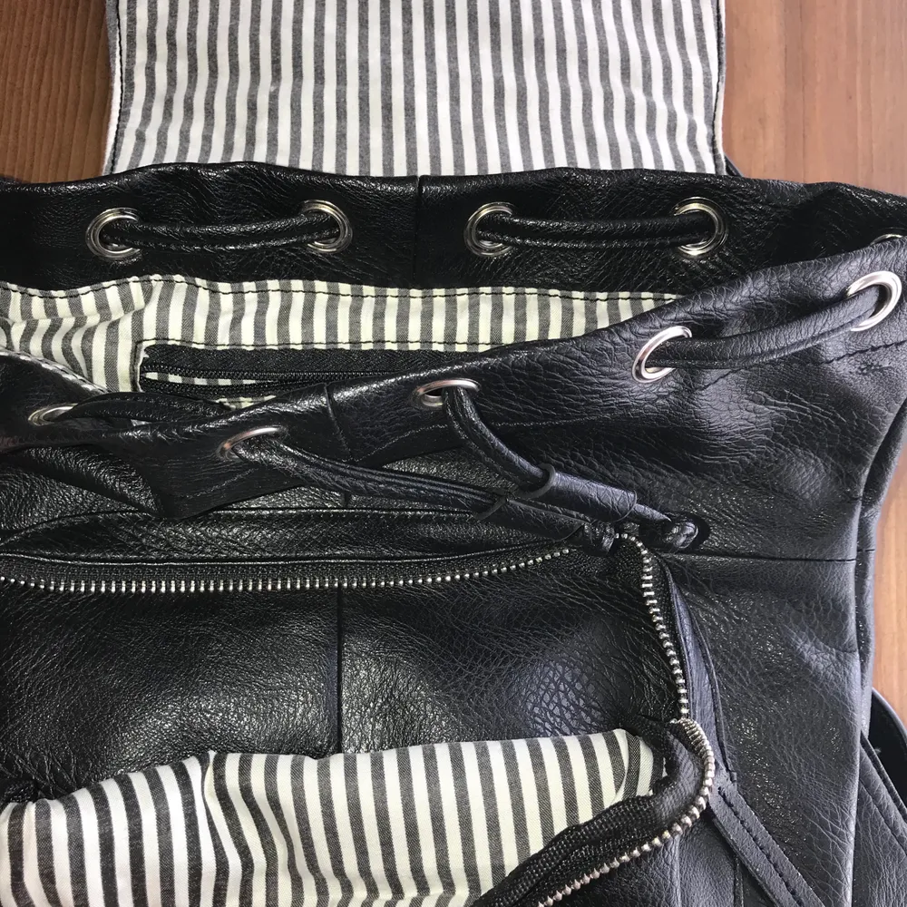 Black vegan leather drawstring closure backpack. Can fit an iPad Pro (10”)  or Air. Great used condition. Magnetic clasp. No fading, loose stitching, holes, tears, rips, snags. Lining is great. Please note the inside of the flap. Smoke and pet free storage space. No other flaws to note.  Happy to bundle. Will gladly take more pics. Disclaimer: Please expect some general wear in all secondhand pre-loved items as they have lived a previous life, so don't expect a mint item. . Väskor.