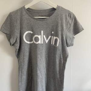 Grå T-shirt från Calvin Klein med vit text. Den andra bilden visar fårgen tydligast. Hör av er vid intresse eller frågor 💕 Köpare står för eventuell frakt 🥰