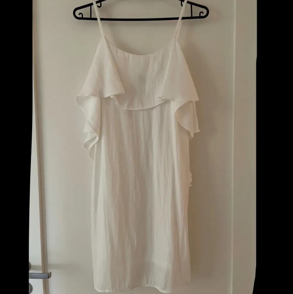 Säljer denna superfina vita klänning i strl 34/XS från MQs märke Zoul! Klänningen är fodrad, har smala axelband och en fin volang upptill som sträcker sig ned lite längs sidan💛 Den är i mycket gott skick, endast använd ett fåtal gånger💛. Klänningar.