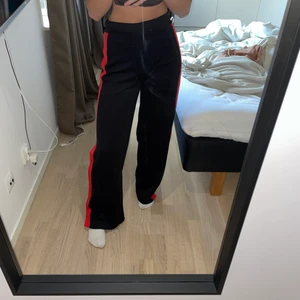 Byxor  - Säljer dessa byxor med en röd rand och knappar på sidorna. 