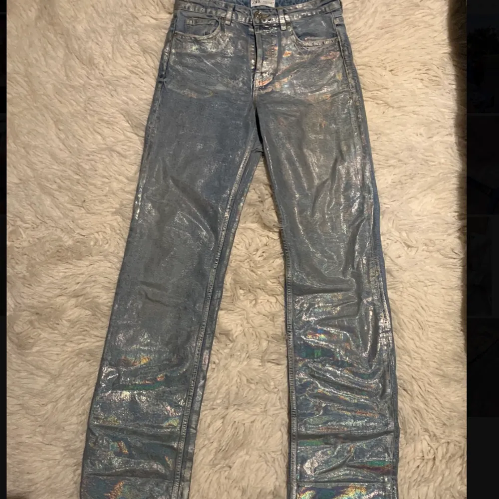 Världens snyggaste jeans från Zara. Ljusblå i grunden med snygg regnbågseffekt. Perfekt passform och långa i benet med rå kant. Snygga både nedvikta och uppvikta. Storlek 36. Väldigt fint skick utan några skador. Köparen står för frakt. Jeans & Byxor.