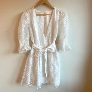 Revolve vit klänning  - Köpt från Revolve, blev fel storlek för mig och går inte för mig att lämna tillbaka vilket är anledningen till att jag säljer. I nyskick (endast testad en gång) och perfekt studentklänning. Storlek L och är i normal passform. Nypris 2 690kr.