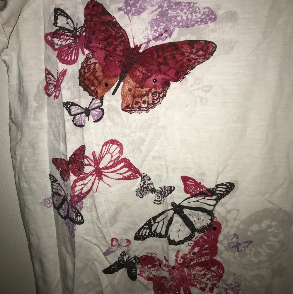 En jätte snygg, vit, vintage t-shirt med blommor och fjärilar. Väldigt fint skick och skönt matrial. Storleken är L, men passar som M också. Kontakta mig för fler bilder. Priset kan diskuteras! 😊❤️. T-shirts.