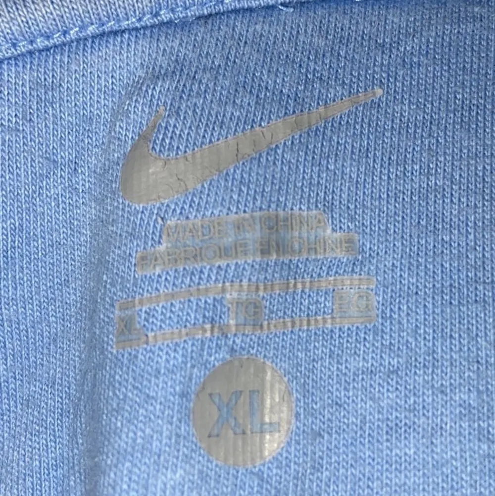 Vi säljer denna ljusblåa college hoodie från Nike som är i storlek XL men den sitter som en lite större M bara. Den är en vintage hoodie från college i North Carolina och har ett coolt och fint mönster på ryggen. Skriv för mer information🥰. Hoodies.