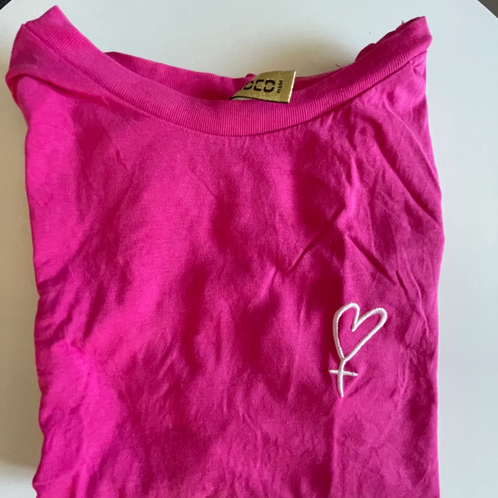 Rosa T-shirt jag köpte på HM. Använt en gång. Ganska kort i modellen. Väldigt fin rosa!. T-shirts.