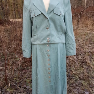 Vintage set kjol och jacka 70 tal 80 tal - Fint retro set från 80 talet. Med Matchande kjol och croppad jacka. Jaackan har axelvaddar och Kjolen har fickor! Dom är i super fint skick, ser helt nya och oanvända ut! Strl M se mått: Jacka: Midja: 100 cm Längd från axel: 52 cm Byst: 116 cm  Kjol: Midja: 84 cm Längd: 90 cm