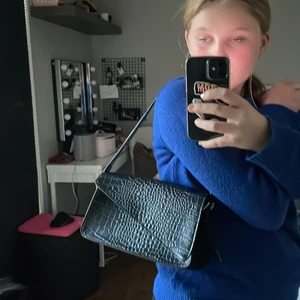 Svart väska - Säljer nu min jätte fina väska från Nelly tror jag, jag minns inte vart jag köpte den. ❤️ Men den är i jätte bra skick då jag bara använt den 1 gång. Säljer för att jag inte får användning av den! ❤️ om man vill ha spårbar frakt kostar de extra! 