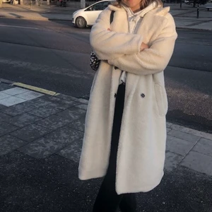 Vit Teddy jacka från NA-KD - Jättefin off white kappa från NA-KD i fake fårull. Storlek 34 men passar 36 också, lite större i modellen så jättefin för en lite oversize look (första bilden är lånad men exakt samma jacka)  🌞💫