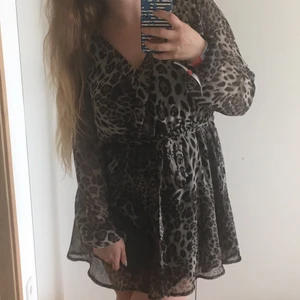 Leopard-mönstrad klänning - Leopard-mönstrad klänning med resår i midja och ärmslutet, samt band i midjan. Använd en gång. Från NLY Trend. Strl 42 🐆