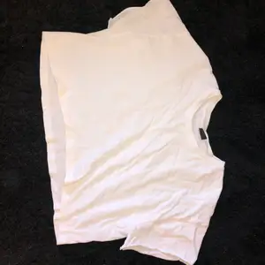 Croppad vit T-shirt från Gina som aldrig har används. Armarna är avklippta men annars är den i bra skick, priset kan diskuteras.