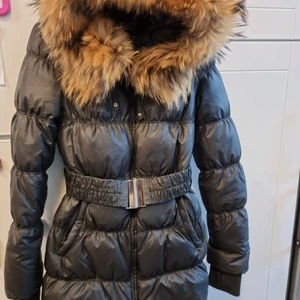 Varm jacka från Hollies I storlek 36 - Jacka från Hollies I storlek 36 är endast använd 2-3 gånger så den är i jättefin skick. Äkta päls, avtagbar bälte 