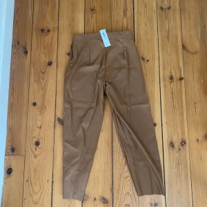 Byxor från Gina tricot - Fina byxor från Gina tricot som aldrig är använda i storlek 38. De är korta i benen på mig som är 170 lång. Rökfritt hem. 