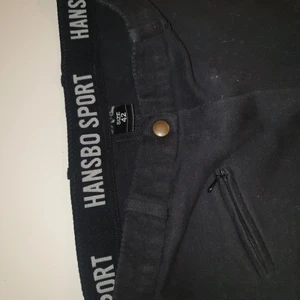 Ridbyxa Hansbo 3/4 skydda med fuskskinn - Ridbyxa hansbo st 42, använda 2 ggr men det finns ett litet hål vid linningen se bild. Annars nyskick