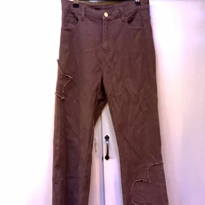 Bruna höga & utsvängda jeans - Coola bruna utsvängda jeans, supersköna! Med fina detaljer, blomma och stjärna. Små fransar därnere. 