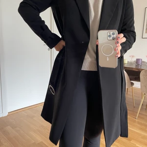 Svart kappa H&M - Medellång kappa i fin kvalite, endast använd 1 gång. Har ett bälte att knyta den i midjan med, nypris 599kr.