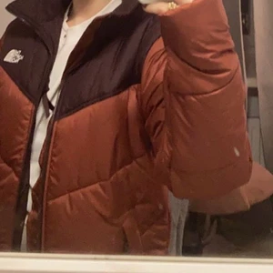 The North Face jacka, brun, storlek s - Jackan är väldigt varm till vintern och fodrad. Den är i nyskick och knappt använd. Jag köpte den i slutet av förra vintern . Den är har en lite ljusare brun färg och en mörkare upptill samt inuti. Den går även att dra åt längt ned på båda sidorna och har en hög krage med mjukt foder. 