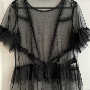 Svart seethrough topp - En svart seethrough tröja som passar perfekt till fest eller roligare dagar! Har klippt bort lappen i nacken eftersom att den sundes väldigt mycket. Många fina detaljer på tröjan som gör den lite roligare! 