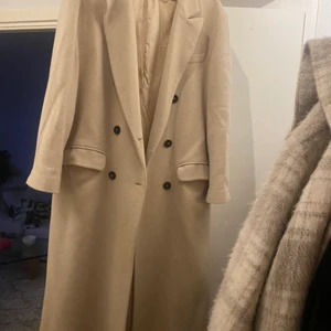 Beige kappa zara  - En beige kappa i ull från zara. Köptes hösten 2020 och användes därefter bara ett par gånger, den är därför i väldigt bra skick.   Nypris: 1300 kr   Storlek: L Jag är 170 cm lång och den passar mig bra då den blir lite oversized i passformen. 