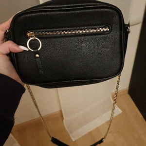 Svart väska från Hm! - Säljer en jätte fin väska från hm som nu är slutsåld! Nästan aldrig använd, bra skick på den. Finns 1 litet fakk inuti väskan och utanpå som ni ser på bild 1 och 3! Kan tänka mig att sälja direkt för 100kr