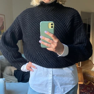 Stickad tröja med glitter - Svart stickad croppad tröja från & Other Stories med hög krage och ballongärm. Diskret glittrig. 