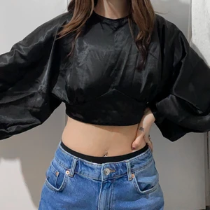 Blus med öppen rygg strl S - Svart blus med knytning i ryggen och knäppning i nacken strl S. Använd endast 1 gång men i mycket bra skick. Silkes material. Passar även XS och M