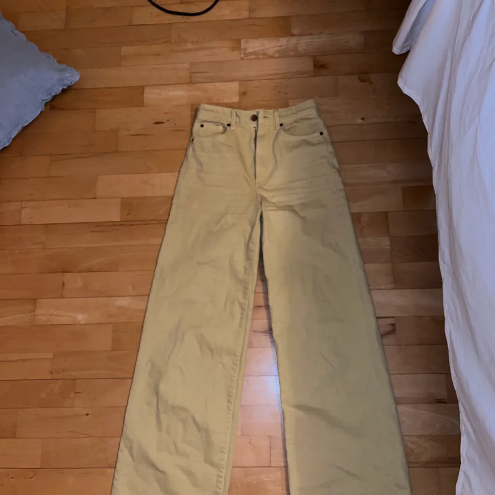 Långa vida ljusgula jeans från HM. Använda ca 3 ggr. Jeansen är hödmidjade. De har två små fläckar vid höger ficka (om man har de på sig) som inte går bort. Därav det låga priset.. Jeans & Byxor.