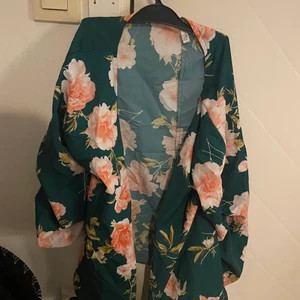 Grönblommig blus - Grönblommig blus/tröja med knytning i midjan. Från NLY trend i storlek 36 men passar även 34.