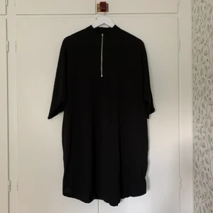 Svart oversized klänning med dragkedja. - Svart, oversized klänning med fickor och dragkedja fram. Köpt från Monki, i mycket bra skick. I storlek S men passar även för större storlekar.  Hämtas på plats eller skickas med post. Vill du ha den skickad tillkommer fraktkostnad på 45 kr (priset för postnords blå påse).