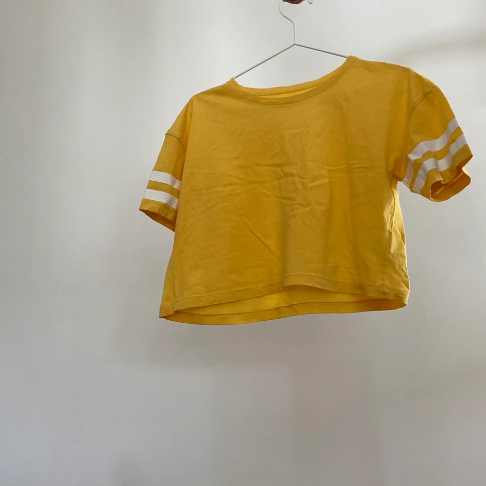 En enkel gul t-shirt med vertikala ränder på ärmarna. Sparsamt använd. Tveka inte att kontakta mig vid frågor! . T-shirts.
