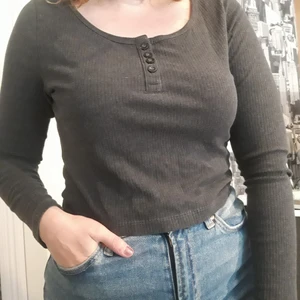 Långärmad topp - Grå långärmad magtröja, ribbad. Knappr på framsidan. Väldigt töjbar. Storlek: Står L men skulle snarare säga M/S. Material: Bomull och Polyester. Inga skador