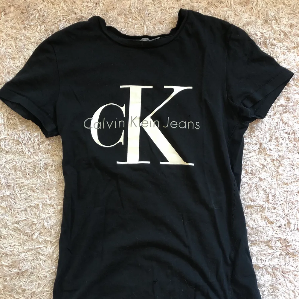 Säljer en svart t shirt från Calvin Klein❣️ Tyvärr är det ett litet hål längst ner på t shirten men man lägger inte märke till det när man har på sig den.. T-shirts.