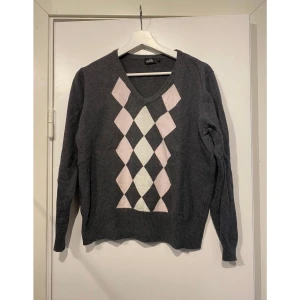 Tröja  - Rutig finstickad tröja i mörkgrått . Ruterna är i rosa och vit 