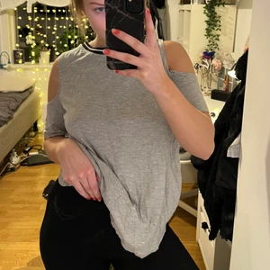 Lång grå top - En lite längre grå top med svart/vit band upptill och fria axlar. Mycket skön att gå runt i hemma eller ha på sig vid finare event. 