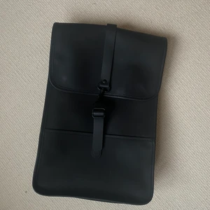 Rains - Ryggsäck från Rains☔️ Använd men i fint skick. 450 kr + 66 kr spårbar frakt. Kan även mötas upp i centrala Jönköping.  Om produkten: Material: 50% polyuretan, 50% pet Vattentät: 8000 mm Andningsförmåga: 0 g/m2/24h Passar för laptop upp till 13" Stängs med tryckknapp Stängs med spänne Detta är en unisexprodukt Bredd: 28 cm Dirt resistant Volym: 8,5 l Höjd: 40 cm Djup: 9 cm