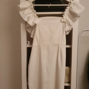 Vit klänning i velour med dragkedja  - Vit klänning med volanger runt ärmarna från märket Vesper. Ganska stretchig. I stolek 10 alltså 38. Använd 1 gång, köpt för 800 kr